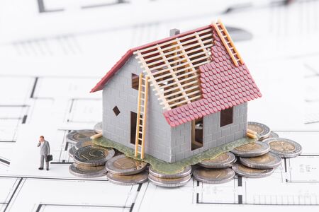 Tiny house stands on coins. The concept of banking, loans, expenses.の写真素材