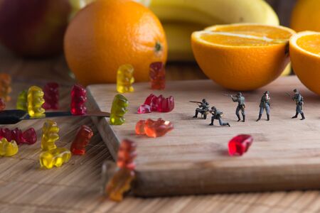 Small figurines fight with jelly bears. The concept make peace not warの写真素材