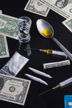 Drugs, syringes and money on a black background.の写真素材