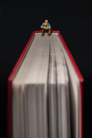 Little figure reading book on bookの写真素材