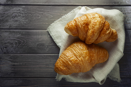 Fresh croissants on wooden table. Top view, copy spaceの写真素材