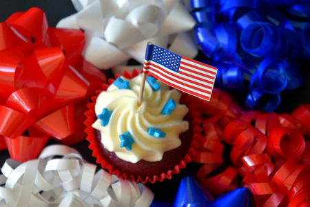 Happy Independence Day celebration, patriotism and holidays concept - close up of glazed muffins or cupcakes decorated with American flags at 4th of july partyの写真素材