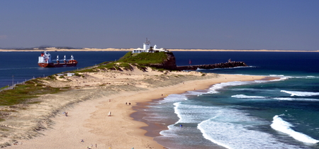 Beach at Newcastle. Nobbley's Lighthouse in the background.の写真素材