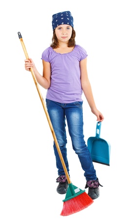 Full-body portrait of a 9-year-old girl in jeans and purple top, blue scarf on head, holding a dustpan and a broom - isolated on whiteの写真素材