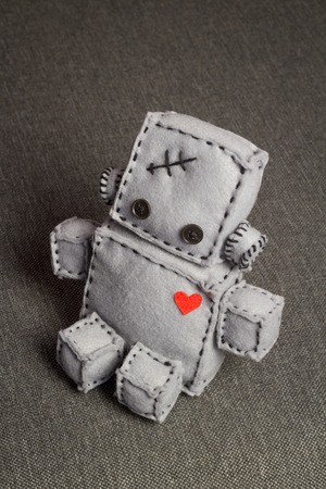 Robot With Heart. Macro Soft Toy at blurred backgroung.