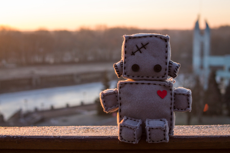 Robot With Heart. Winter sunrise outdoors. Macro Soft Toy at blurred backgroung.の写真素材