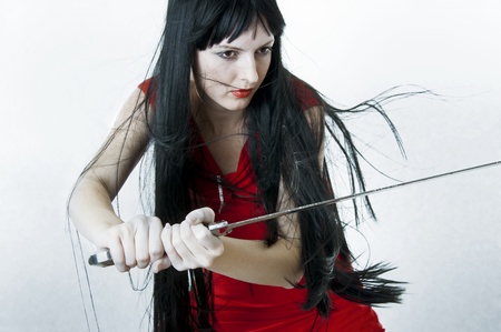 Sexual woman fighter with flying hair holds medieval sword
