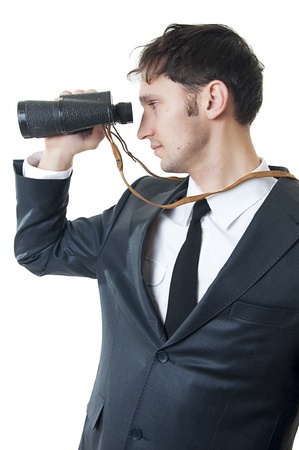 Portrait of a successful young business man looking through binoculars isolated on white backgroundの写真素材