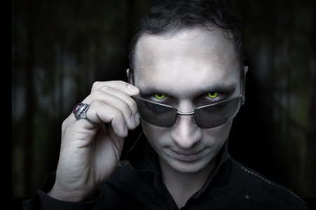 Portrait of Night male vampire or demon style make up on dark backgroundの写真素材