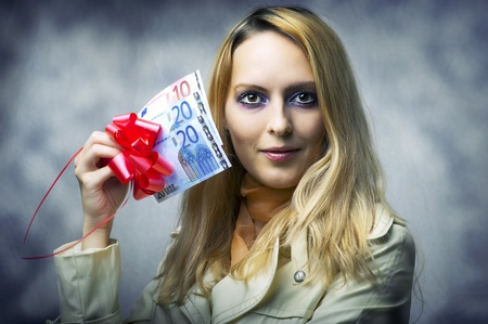 Fashion portrait of young beautiful woman winner holding money - 50 (fifty) euro.の写真素材