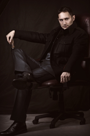 Fashion retro portrait of handsome fashionable man in coat and suitの写真素材