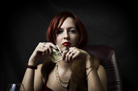 Glamour portrait of sexy woman face with bright evening make up for party and jewelry gold rings with precious stones sitting on the tableの写真素材