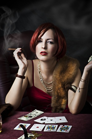 Fashion portrait of young adult woman with red hair in retro style - 30s,50s, 40s years. Player poker or fortune tellerのeditorial素材