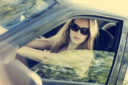 Beautiful young sexy woman in car looking from window on nature background. の写真素材