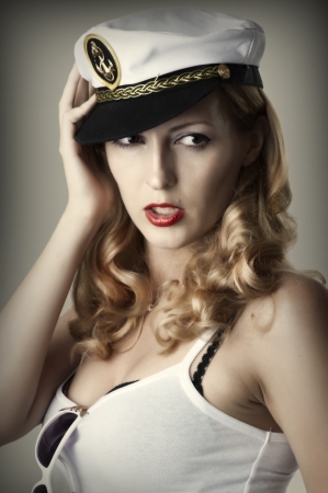 Fashion portrait of young sexy woman with red lips and captain cap の写真素材