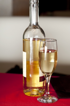 Bottle and glass of white wine at restaurant tableの写真素材