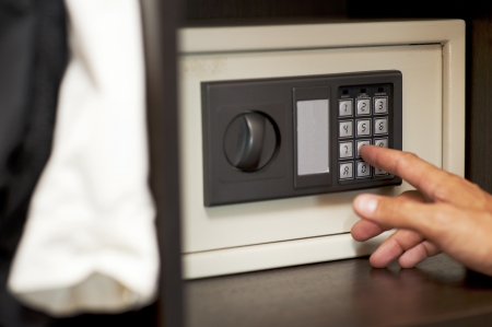 Male hand gaining an electronic code to the locked safe