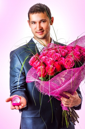 Valentines Man with flowers and ring un pink box. Proposal scene の写真素材