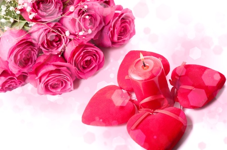 Art Design with beautiful big bouquet of pink roses, candle and red heartsの写真素材