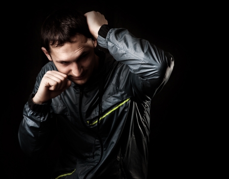 Mixed martial arts. Portrait of Young street fighter on black background