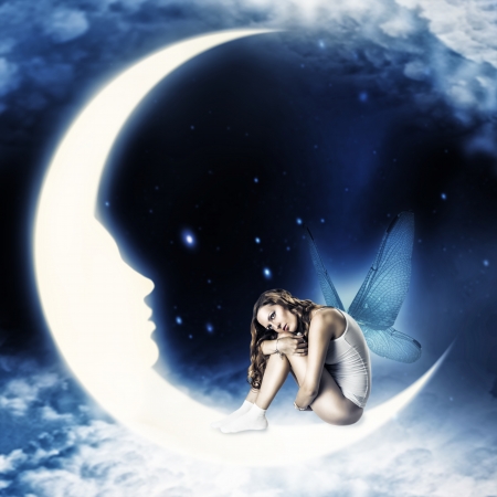 Beautiful woman fairy with wings sitting on moon with face in the star and clouds  skyの写真素材