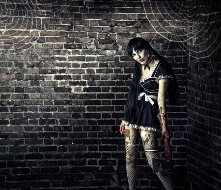 Horror. Sexy dirty woman zombie  holding a bloody ax の写真素材