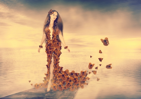 Beautiful young woman wearing orange butterflies dressの写真素材