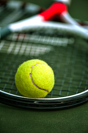 Close up view of tennis racket and ball on the clay tennis court. Focus on ballの写真素材