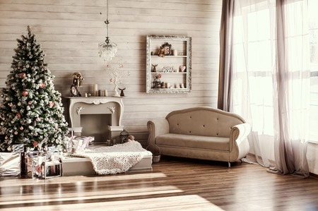 Christmas mornig at home. No people. Christnas eve, gift boxes fireplace and decorations in beautiful white roomの写真素材