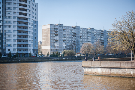 KALININGRAD, RUSSIA - APRIL 10, 2017: Touristic place in the city is a Fish Village. Soviet residential high-rise buildings and fishermen catch fish in the river pregolyaのeditorial素材