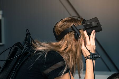 Virtual reality with full immersion. The girl is wearing virtual reality glasses on her head