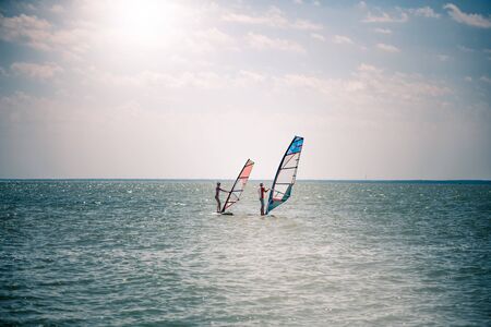 Romance in the sea couple man and woman together sailing on a windsurfing board while on vacation in...