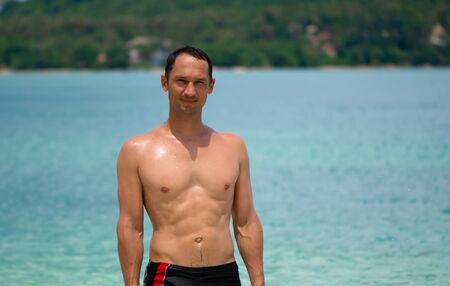Portrait of a handsome happy man at tropical resort with smile on Rang Yai Island in Thailand