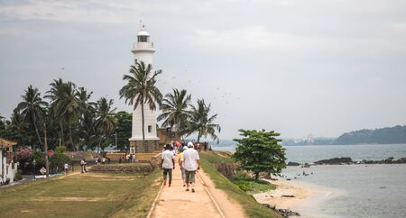 GALLE, SRI LANKA - MARCH 16, 2019: Lighthouse at Galle Fortress in Sri Lanka for palm trees by the seaのeditorial素材