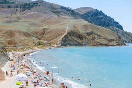 MEGANOM, CRIMEA - JULY, 20, 2016 People and tourists on Meganom beach. Near Meganom mountain range and peninsula in southeastern Crimea between Feodosia and Sudakのeditorial素材