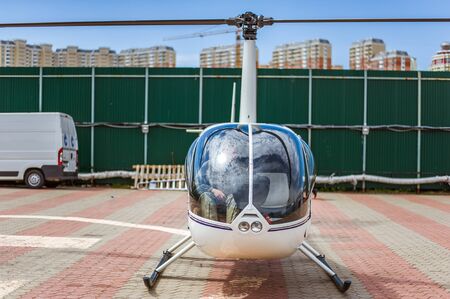A small private helicopter stands in a helicopter parking lot at the helipadの写真素材