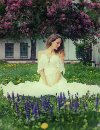 Beautiful young adult woman model Posing in a trendy white lace dress brideの写真素材