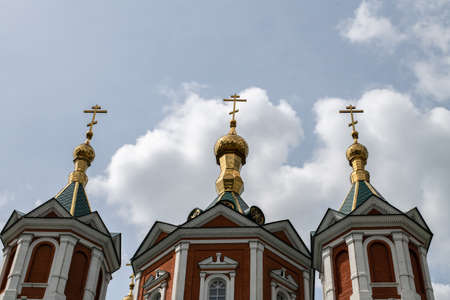 Cross-driven cathedral in Kolomna Kremlin from red bricks with golden domes and crosses. Russian...