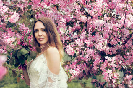 Beautiful young adult woman model Posing in a trendy white lace dress brideの写真素材
