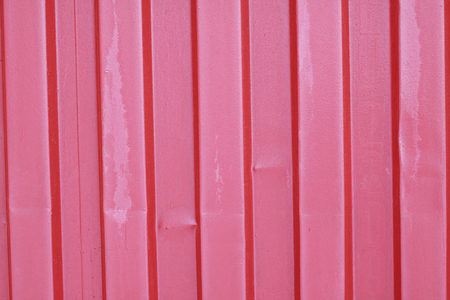 Old, red, crumpled, crimson metal sheet wall fence for industrial building and construction. Abstract red metal door texture background close up.の写真素材