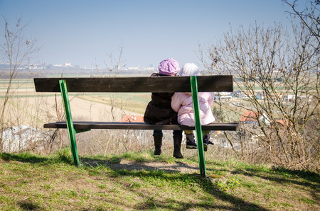 two children sitting on the benchの写真素材