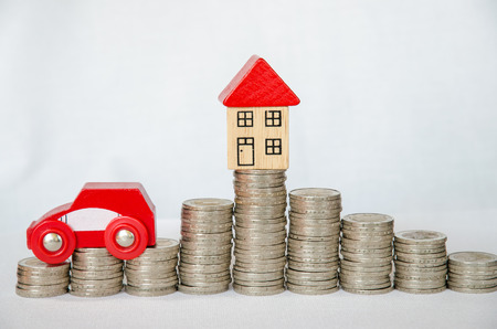 detail of coins, house and car on white backgroundの写真素材