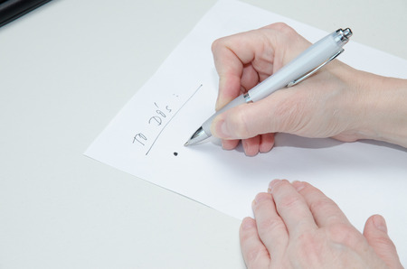 hand with pen and white to do´s list paperの写真素材