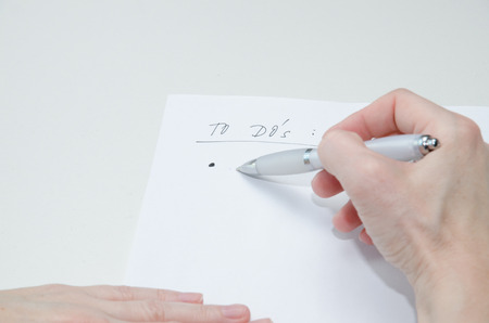 hand with pen and white to do´s list paperの写真素材