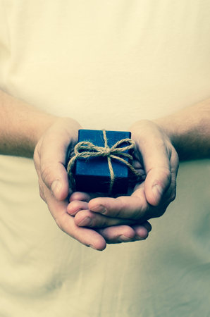blue gift box in male handsの写真素材