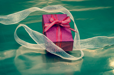 red gift box with shiny ribbonの写真素材