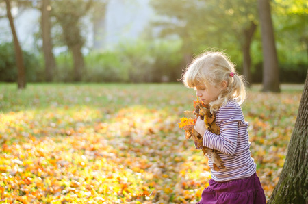 beautiful blond girl in autumn parkの写真素材