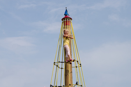 beautiful blond girl playing on playgroundの写真素材