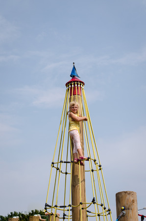 beautiful blond girl playing on playgroundの写真素材