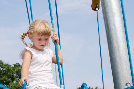 beautiful blond girl playing on playgroundの写真素材